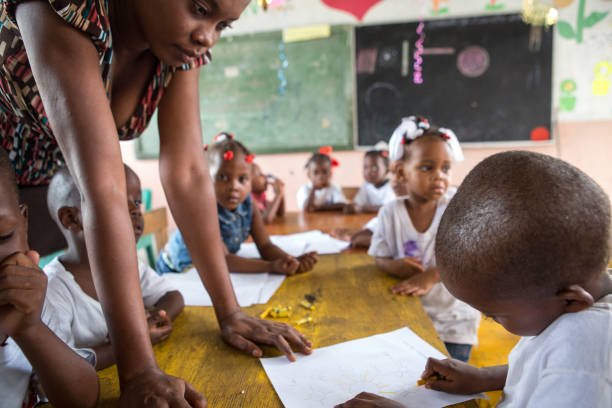 A teacher helping students with their school supplies